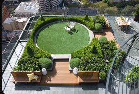 Rooftop planting design with herbs, wood decking, and urban skyline